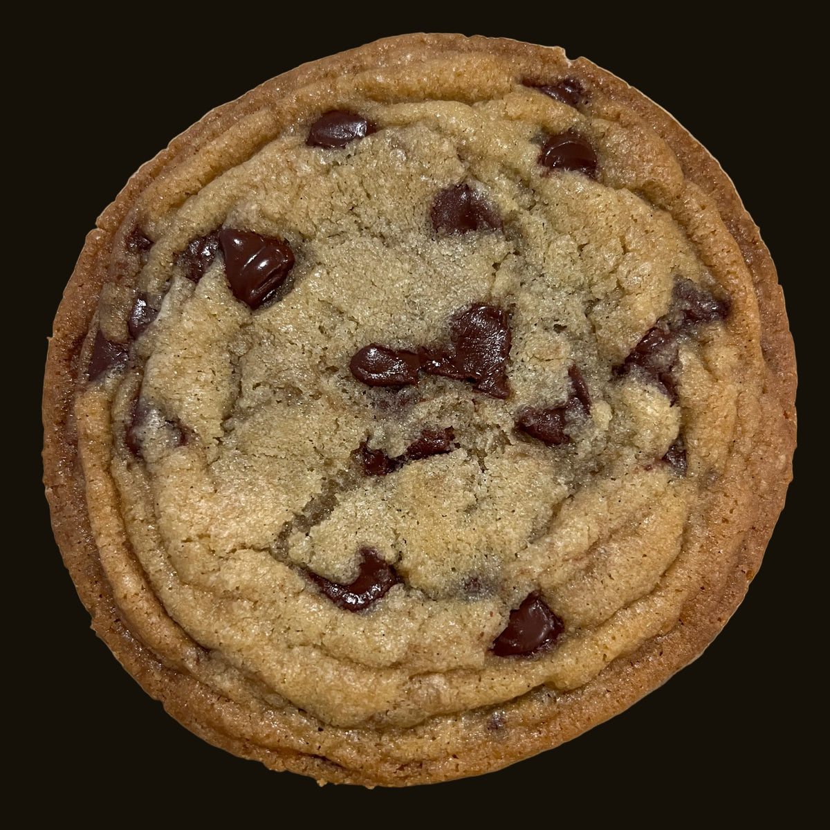 A single chocolate chip cookie photographed from above on a light beige surface. The cookie is golden brown with several dark brown chocolate chunks embedded in the center.